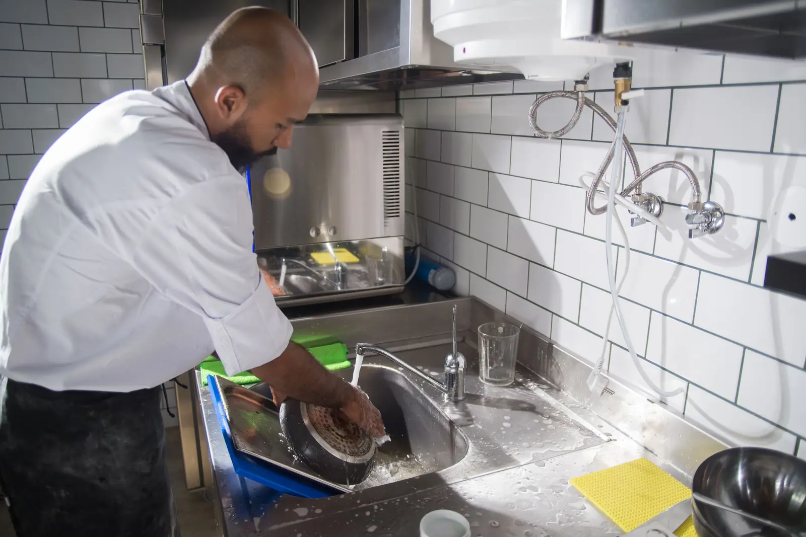 Nettoyage à la plonge inox d'une cuisine professionnelle